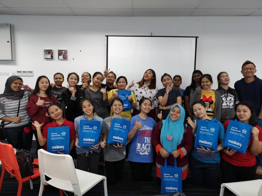 Maideasy cleaners at a team orientation session holding Maideasy welcome bags