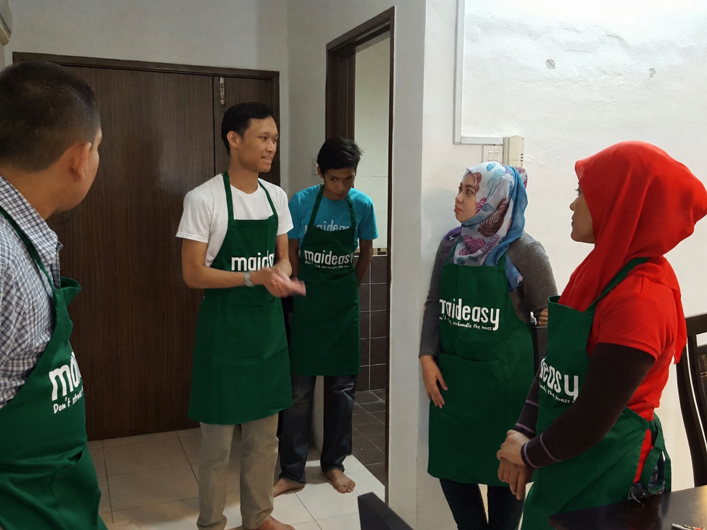 Maideasy cleaners in green aprons during a team training session